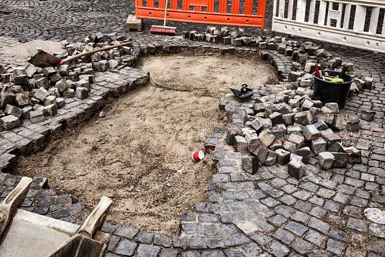 AUSSENANLAGEN Ein Bild einer halb verlegten Pflastersteinfläche.