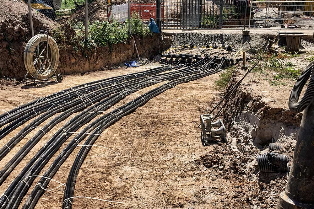 LEITUNGSBAU Ein Bild von Leitungen, welche in einer Vertiefung verlegt werden.