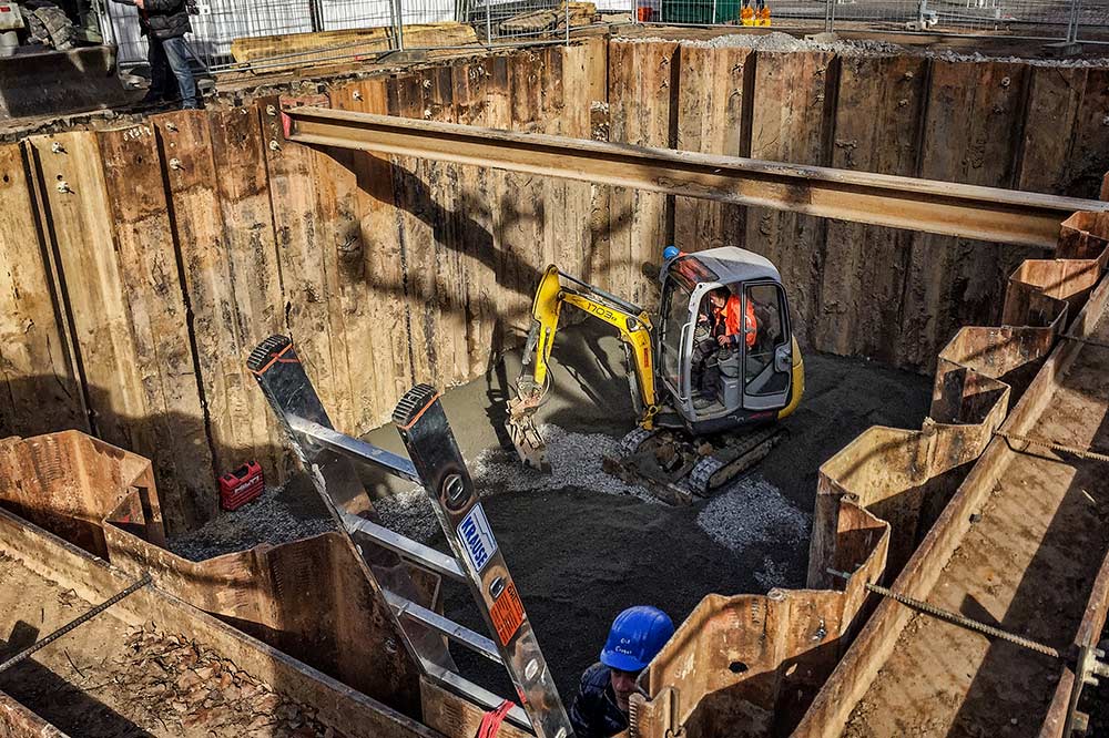 TIEFBAU Ein Bild von einem kleinen Bagger in einer ausgehobenen und verschalten Baugrube.
